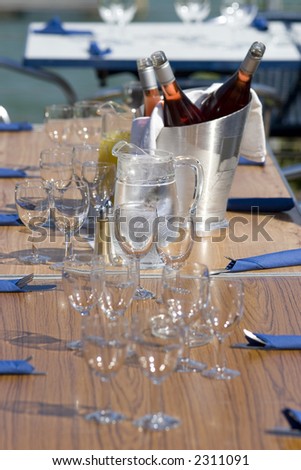 A table in the sunshine laid out for lunch complete with chilled wine in an ice bucket.