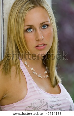 Portrait of a naturally beautiful young blue eyed woman leaning in a doorway
