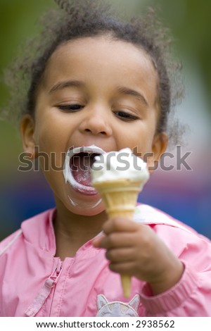 A beautiful mixed race little girl eating an ice cream and about to take a great big bite