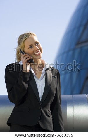A beautiful young female executive using her mobile phone in a hi-tech urban setting