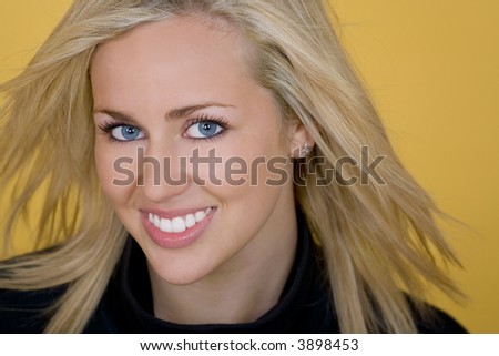 A gorgeous young blond woman with striking blue eyes looking beautiful and happy