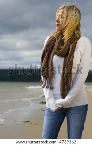 stock photo : A beautiful blond haired blue eyed young woman standing alone 