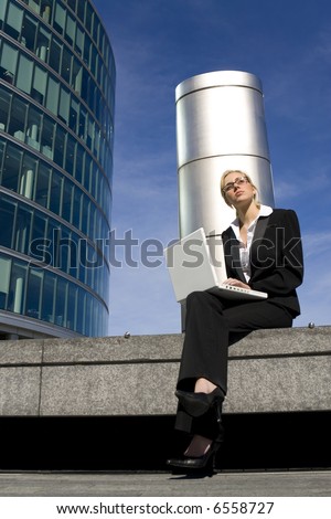 A beautiful young female executive using her laptop in a hi-tech business environment
