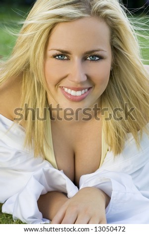 A beautiful blond haired blue eyed model wearing a white shirt shot outside using natural light
