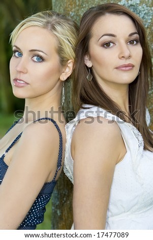 Two beautiful young women one blond and one brunette shot outside with natural light