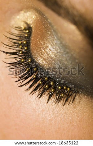 A macro close up of a beautiful woman\'s made up eye with false eyelashes