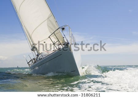 A beautiful white yachts racing close to the camera on a bright sunny day