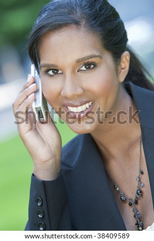 A beautiful young Asian businesswoman with a wonderful smile chatting on her cell phone.
