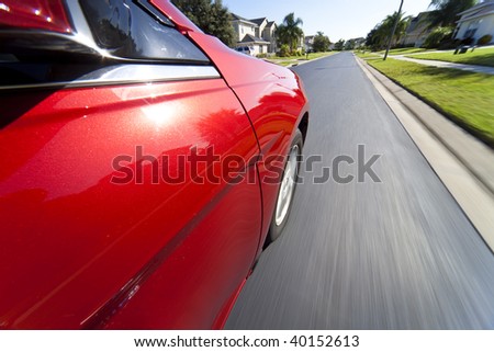 Slow shutter speed mounted camera shot taken from a car driving at speed through a suburban neighborhood.