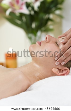 A young woman relaxing at a health spa while having a relaxing destressing head massage