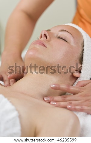 A young woman relaxing at a health spa while having a facial treatment or relaxing massage