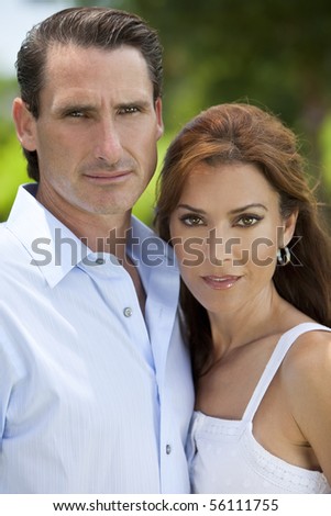 Portrait shot of an attractive, successful and happy middle aged man and woman couple in their thirties, shot outside in natural light.