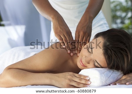 A young woman relaxing at a health spa while having a massage