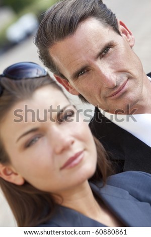 An outdoor portrait of handsome middle aged man and beautiful young woman couple, the focus is on the man in the background