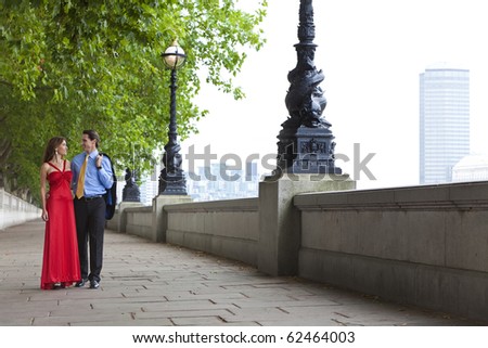 Romantic man and woman couple holding hands walking by the River Thames in London, England, Great Britain