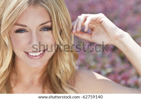 Portrait of naturally beautiful woman in her twenties with blond hair and blue eyes, shot outside in natural sunlight