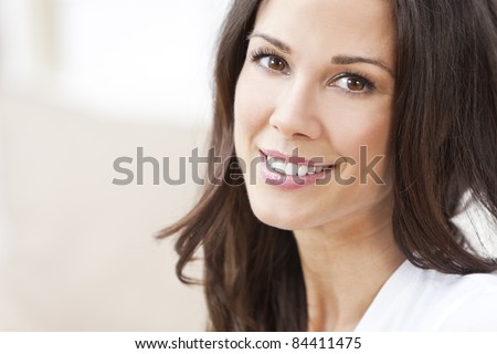 Portrait of a happy beautiful brunette young woman with perfect teeth & smile