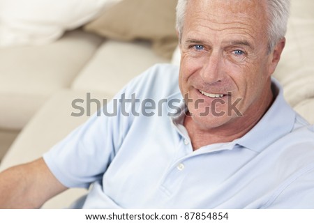 Happy and healthy senior man sitting on a sofa at home smiling and happy