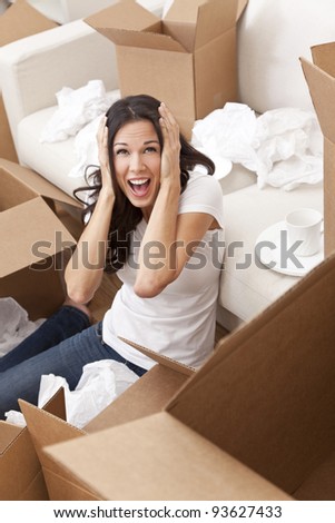 A beautiful single young woman screaming with stress while unpacking boxes and moving into a new home.