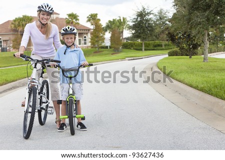 A young family of woman and boy child, mother and son, cycling together.