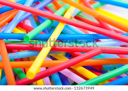 Closeup of Chaotic pile of multi-color cocktail straws isolated on white
