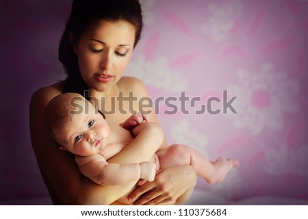 Portrait of a beautiful mother with her newborn baby indoor