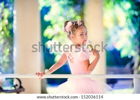 Little Ballerina Girl Doing Ballet Bar Exercises With Flower On Her Hand At Beautiful Garden Background