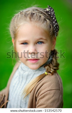 preschooler girl in casual clothes at green nature park background