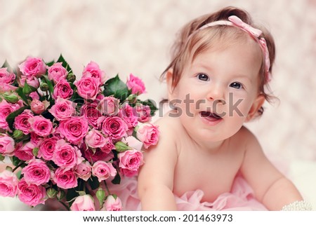 Little baby girl with flowers smiling