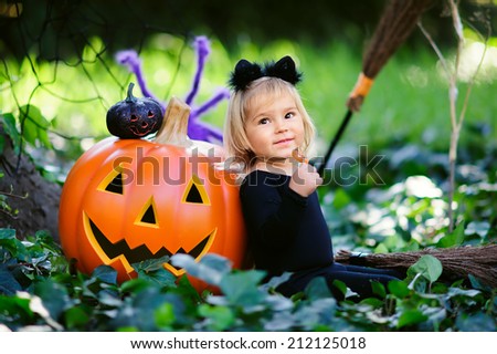 little girl in halloween costume eat sweet tricks with jack pumpkin
