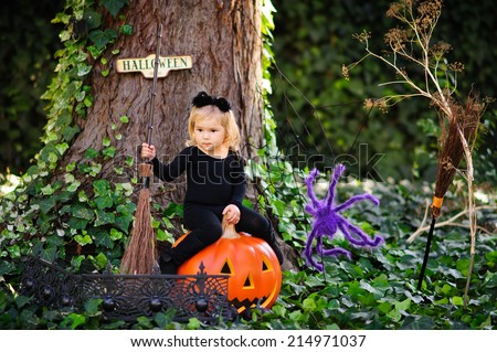 Little cute happy girl in cat costume celebrate Halloween