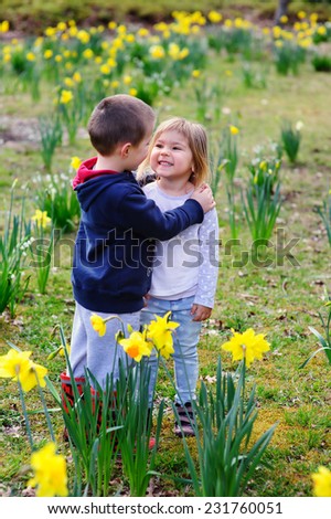 Two happy little friends kids boy and girl playing in blossoming garden
