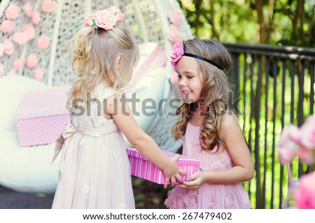 little girl present a party birthday gift to her friend