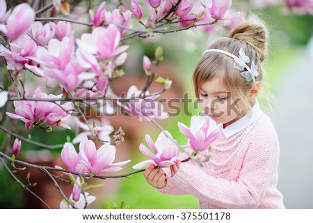 Cute spring  fashion girl under blossom magnolia tree