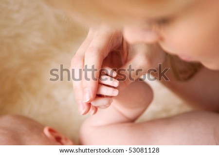 mother taking her newborn baby\'s hand