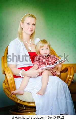 Mother and daughter sit and read the books and tell fairy tales