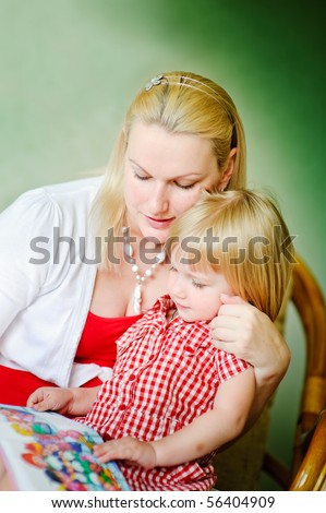 Mother and daughter sit and read the books and tell fairy tales