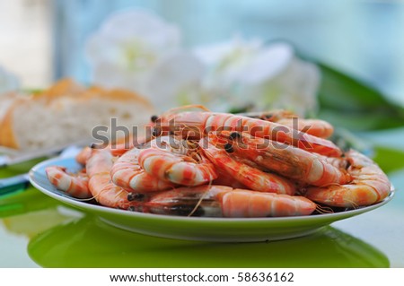 dish served with a lot of fried tiger prawns with bread on the table with flowers