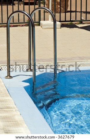 Pool corner fragment with metal ladder and blue water