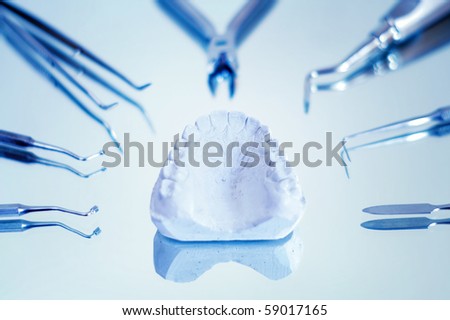 Gypsum dentures surrounded by dental instruments , shallow dof