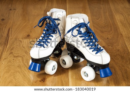 Pair of roller skates on a wooden background