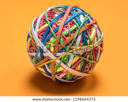 Colorful rubber band ball on orange background