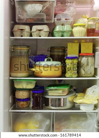 Refrigerator inside full of assorted food ingredients, fruit, vegetables, meat and dairy products