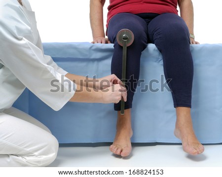 Physiotherapist measuring active range of motion of older patient\'s lower limb using manual goniometer