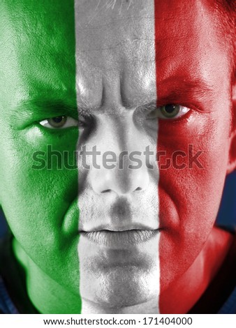 Closeup of young Italian supporter face painted with national flag colors