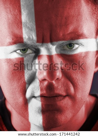 Closeup of young Danish supporter face painted red with white cross