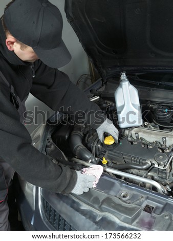 Auto mechanic unscrewing oil filler cap