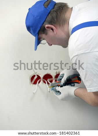 Electrician stripping electrical wires for wall socket