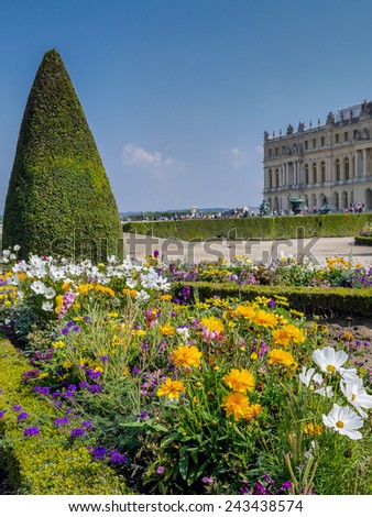 VERSAILLES FRANCE - AUGUST 28 2013: Fancy flowerbed in Versailles garden with Versailles Palace in the background, Versailles, France