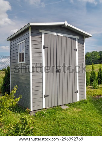 Wooden garden tools shed painted in gray color
